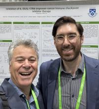 Columbia's executive in residence, Mr. Gad Berdugo (left), and assistant professor of medicine, Dr. Brian Henick (right), in front of Mor Lab's research poster at AACR annual meeting.